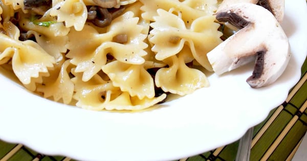 Farfalle with mushrooms, raw ham chips