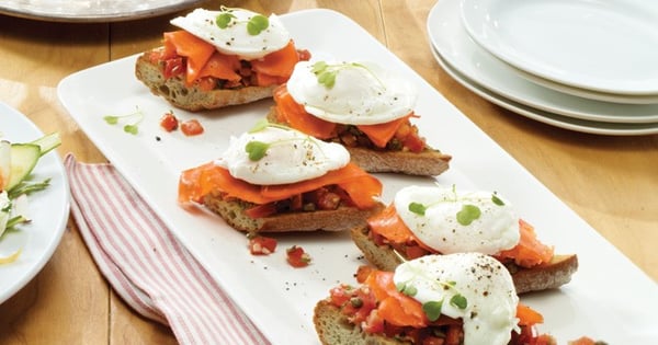 Poached egg on toast with herbed tomatoes and smoked salmon