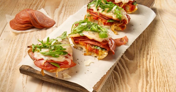 Ciabatta pizza with Amoré pepperoni, caramelized onions and arugula salad