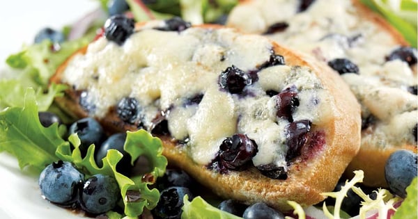 Sweet Ermite–blueberry crostini on a bed of greens
