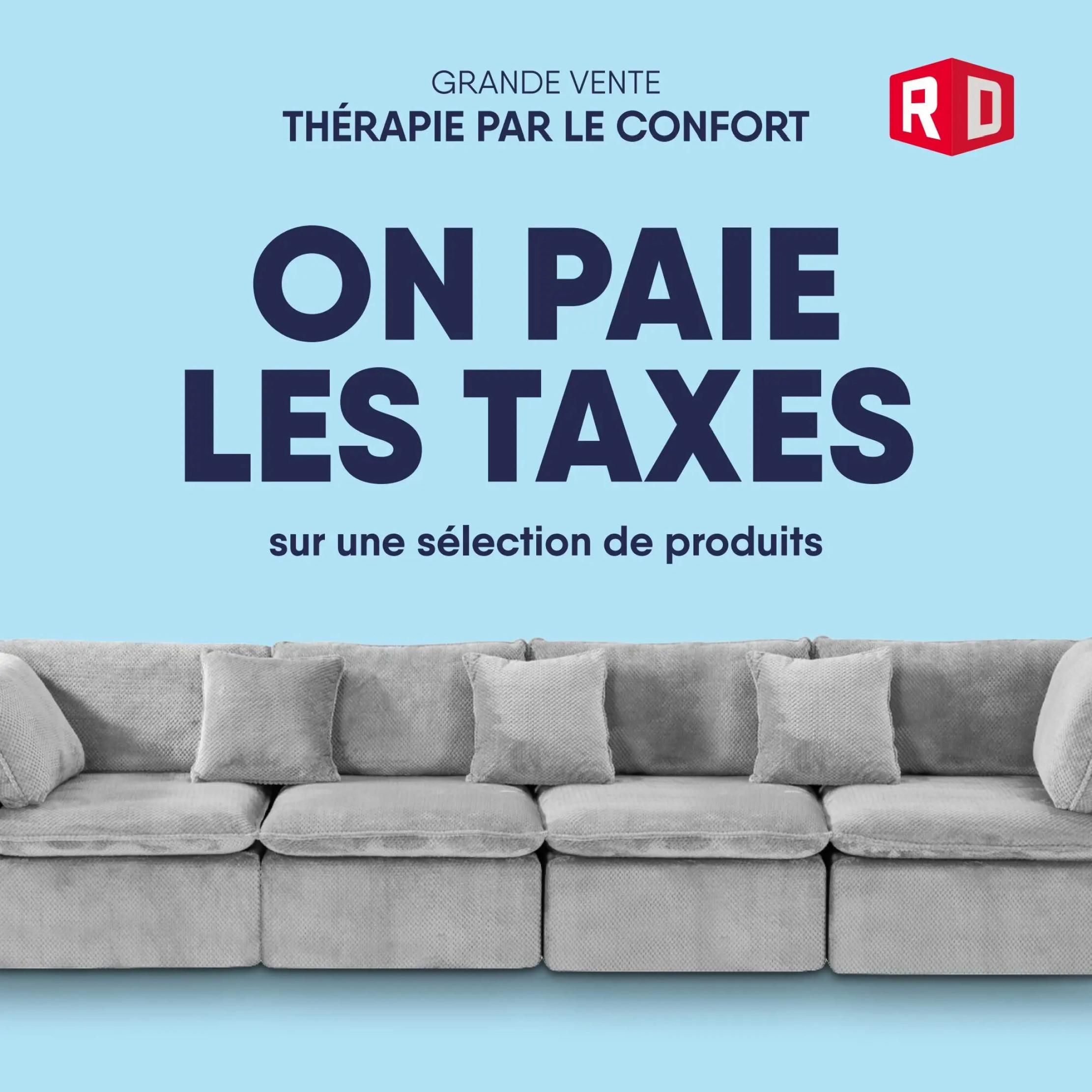 RD Furniture flyer: Grande Vente 'Thérapie par le Confort' - ON PAIE LES TAXES on a selection of products. Features a large grey sectional sofa with multiple plush cushions. The sale promotion 'We Pay the Taxes' is prominently displayed in large, bold, dark blue lettering.