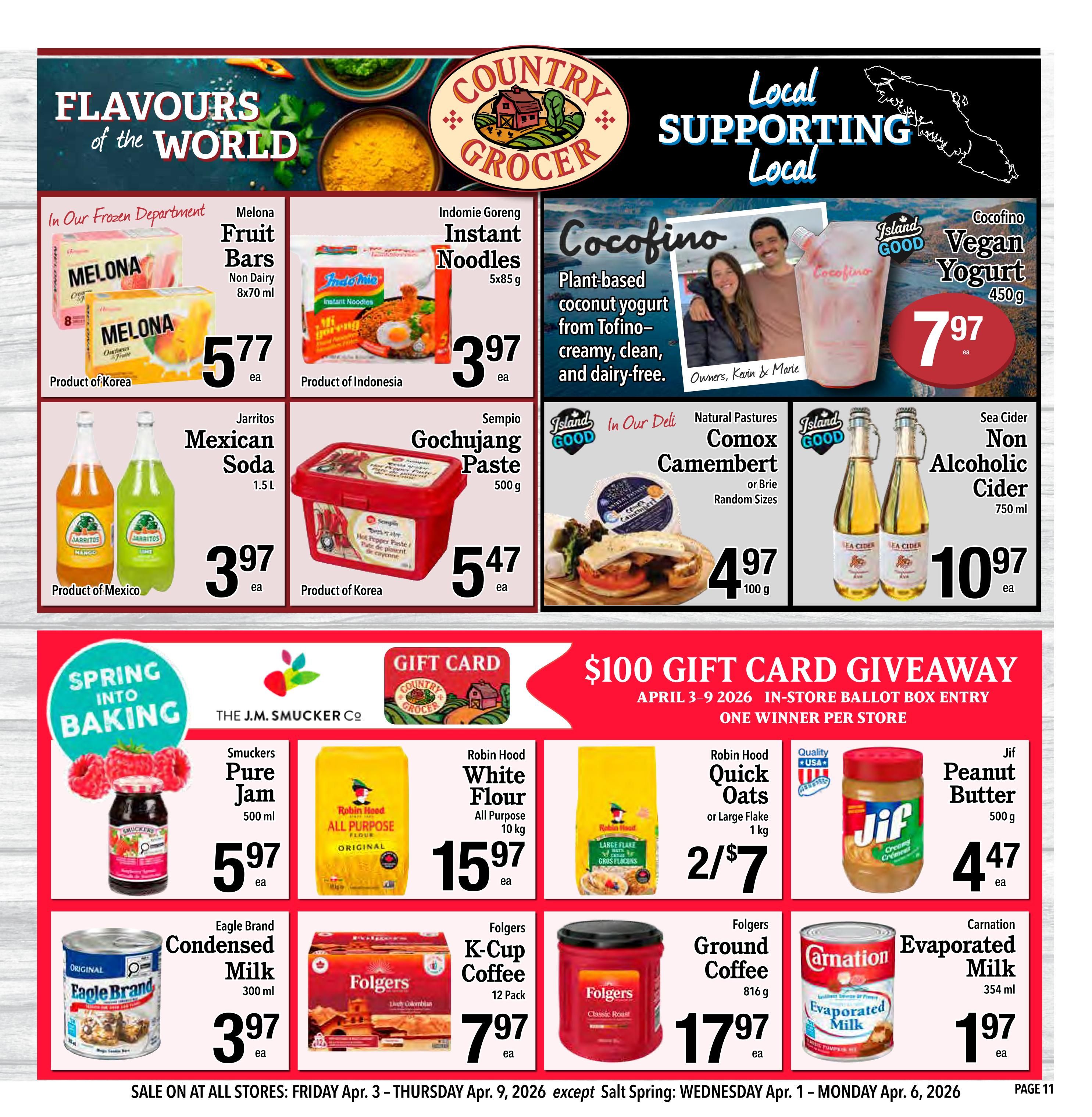 Country Grocer weekly flyer specials for April 3 to April 9, 2026. Page 11 features 'Flavours of the World' and 'Local Supporting Local' sections. Frozen department offers Melona Fruit Bars for $5.77. Indomie Goreng Instant Noodles (5x85g) are $3.97. Cocofino Plant-based coconut yogurt (450g) is $7.97. Jarritos Mexican Soda (1.5L) is $3.97. Sempio Gochujang Paste (500g) is $5.47. Natural Pastures Comox Camembert or Brie is $4.97 per 100g. Sea Cider Non Alcoholic Cider (750ml) is $10.97. The 'Spring Into Baking' section includes Smuckers Pure Jam (500ml) for $5.97. Baking essentials include Robin Hood All Purpose Flour (10kg) for $15.97, Robin Hood Quick Oats (1kg) for 2 for $7, and Jif Peanut Butter (500g) for $4.47. Eagle Brand Condensed Milk (300ml) is $3.97. Folgers K-Cup Coffee (12 Pack) is $7.97. Folgers Ground Coffee (816g) is $17.97. Carnation Evaporated Milk (354ml) is $1.97. A $100 Gift Card Giveaway is happening from April 3-9, 2026, with one winner per store. Sale is valid from Friday, April 3 to Thursday, April 9, 2026, except Salt Spring: Wednesday, April 1 to Monday, April 6, 2026.