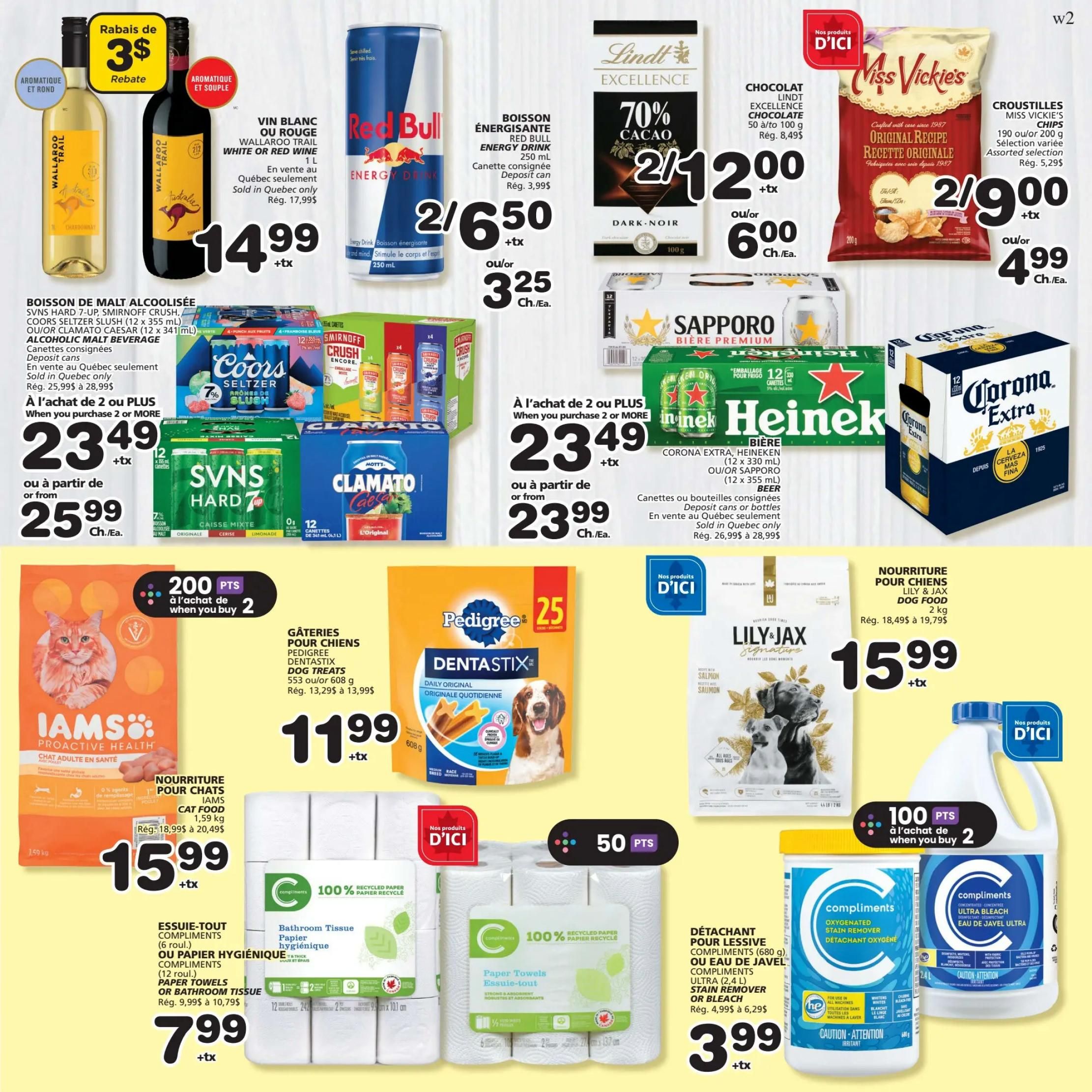 IGA Weekly Flyer Specials Page 6: Features Wallaroo Trail White or Red Wine at $14.99, with a $3 rebate. Red Bull Energy Drink (250 ml) is 2 for $6.50 or $3.25 each. Lindt Excellence 70% Cacao Chocolate (100 g) is 2 for $12.00 or $6.00 each. Miss Vickie's Chips (190 or 200 g) are 2 for $9.00 or $4.99 each. Alcoholic Malt Beverages including Boisson de Malt Coolisée, SVNS Hard 7-Up, Smirnoff Crush, Coors Seltzer Slush, and Clamato Caesar are 2 for $23.49 or $25.99 each. Beer specials include Corona Extra, Heineken, and Sapporo (12 x 330 ml or 12 x 355 ml) for 2 for $23.49 or $23.99 each. Pet food includes Iams Cat Food (1.59 kg) for $15.99 and Lily & Jax Dog Food (2 kg) for $15.99. Pedigree Dentastix Dog Treats (553 g or 608 g) are $11.99. Compliments Paper Towels (6 rolls) or Compliments Bathroom Tissue (12 rolls) are $7.99. Compliments Oxygenated Stain Remover (680 g) or Compliments Ultra Bleach (2.4 L) are $3.99. Earn 200 IGA points when you buy 2 of select items.