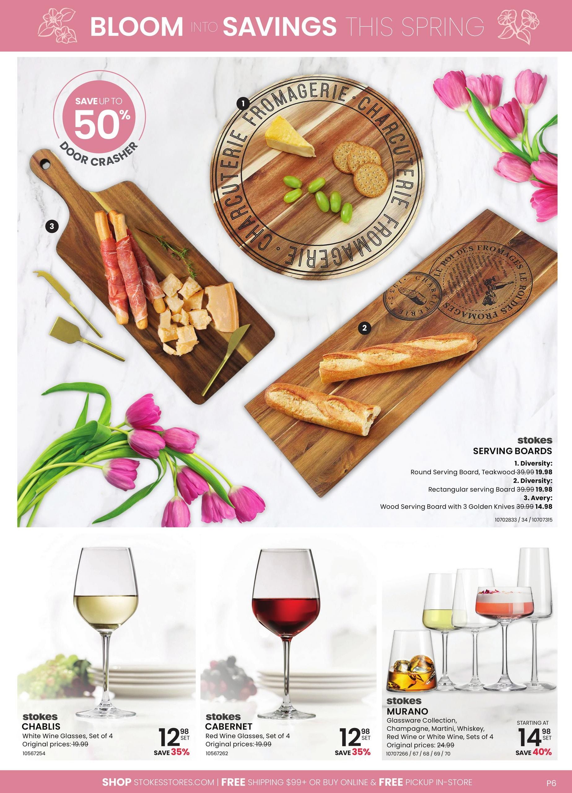 Stokes flyer page 6 featuring 'Bloom Into Savings This Spring'. A 'Save Up To 50% Door Crasher' promotion is highlighted. Serving boards are on display: the Diversity Round Serving Board in teakwood is $19.98 (originally $39.99), the Diversity Rectangular Serving Board is $19.98 (originally $39.99), and the Avery Wood Serving Board with 3 Golden Knives is $14.98 (originally $39.99). Below, Stokes Chablis White Wine Glasses, Set of 4, are on sale for $12.98 (originally $19.99), saving 35%. Stokes Cabernet Red Wine Glasses, Set of 4, are also $12.98 (originally $19.99), saving 35%. The Stokes Murano Glassware Collection, including champagne, martini, and whiskey glasses, starts at $14.98 (originally $24.99), saving 40%.