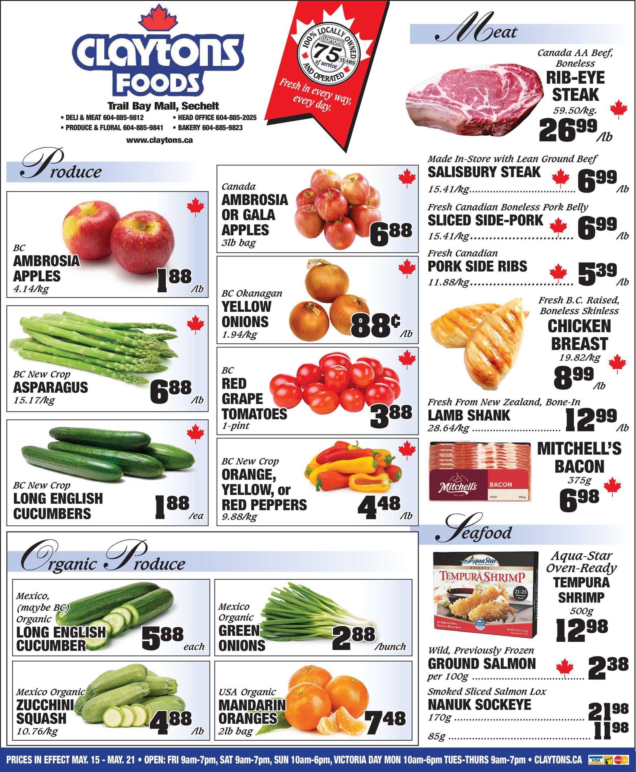 Claytons Foods flyer page 1 featuring produce and meat specials. Produce includes BC Ambrosia Apples for $1.88/lb, Canada Ambrosia or Gala Apples 3lb bag for $6.88, BC Okanagan Yellow Onions for $0.88/lb, BC Red Grape Tomatoes 1-pint for $3.88, BC New Crop Asparagus for $6.88/lb, BC New Crop Long English Cucumbers for $1.88 each, BC New Crop Orange, Yellow, or Red Peppers for $4.48/lb. Organic Produce includes Mexico (maybe BC) Organic Long English Cucumber for $5.88 each, Mexico Organic Green Onions for $2.88/bunch, Mexico Organic Zucchini Squash for $4.88/lb, and USA Organic Mandarin Oranges 2lb bag for $7.48. Meat specials include Canada AA Beef Boneless Rib-Eye Steak for $26.99/lb, Made-in-Store with Lean Ground Beef Salisbury Steak for $6.99/lb, Fresh Canadian Boneless Pork Belly Sliced Side-Pork for $6.99/lb, Fresh Canadian Pork Side Ribs for $5.39/lb, Fresh B.C. Raised, Boneless Skinless Chicken Breast for $8.99/lb, Fresh From New Zealand, Bone-In Lamb Shank for $12.99/lb, and Mitchell's Bacon 375g for $6.98. Seafood includes Aqua-Star Oven-Ready Tempura Shrimp 500g for $12.98, Wild, Previously Frozen Ground Salmon per 100g for $2.38, and Smoked Sliced Salmon Lox Nanuk Sockeye 170g for $21.98 and 85g for $11.98. Prices are in effect May 15 - May 21. Store hours and website are also listed.