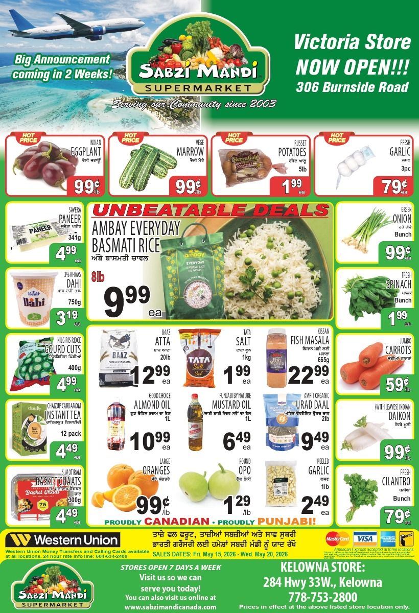 Sabzi Mandi Supermarket flyer. The top of the page features an image of an airplane flying over a tropical ocean with text 'Big Announcement coming in 2 Weeks!'. The Sabzi Mandi Supermarket logo is prominently displayed. To the right, it announces 'Victoria Store NOW OPEN!!!' at '306 Burnside Road'. The flyer highlights 'HOT PRICE' deals including Indian Eggplant for 99¢ per lb, Vege Marrow for 99¢ per lb, Russet Potatoes 5lb for $1.99, and Fresh Garlic 3 pieces for 79¢. A large section titled 'UNBEATABLE DEALS' showcases Ambay Everyday Basmati Rice, 8lb for $9.99. Other deals in this section include Savera Paneer 341g for $4.99, Green Onion a bunch for 99¢, and Fresh Spinach a bunch for $1.99. Further offers include 3% Khas Dahi 750g for $3.19, Nilgiris Ridge Gourd Cuts 400g for $4.99, Baaz Atta 20lb for $12.99, Tata Salt 1kg for $1.99, and Kissani Fish Masala 665g for $22.99. Jumbo Carrots are available for 59¢ per lb. Additional grocery items featured are Chaizup Cardamom Instant Tea 12 pack for $4.49, Good Choice Almond Oil 1L for $10.99, Punjabi By Nature Mustard Oil 1L for $6.49, Amrit Organic Urad Daal 2lb for $9.49, and Indian Daikon (with leaves) for 99¢ per lb. Sweet and savoury snacks include S. Motiram Basket Chaats 300g for $4.49. Fresh produce deals continue with Large Oranges for 99¢ per lb, Round Opo for $1.29 per lb, Peeled Garlic 1lb for $2.49, and Fresh Cilantro a bunch for 79¢. The bottom of the flyer states 'PROUDLY CANADIAN • PROUDLY PUNJABI!' and includes Western Union services information. The sales dates are Friday, May 15, 2026 to Wednesday, May 20, 2026. Sabzi Mandi Supermarket is open 7 days a week, with online shopping available at www.sabzimandicanada.com. The Kelowna store is located at 284 Hwy 33W., Kelowna, phone 778-753-2800, with prices in effect at this location only.