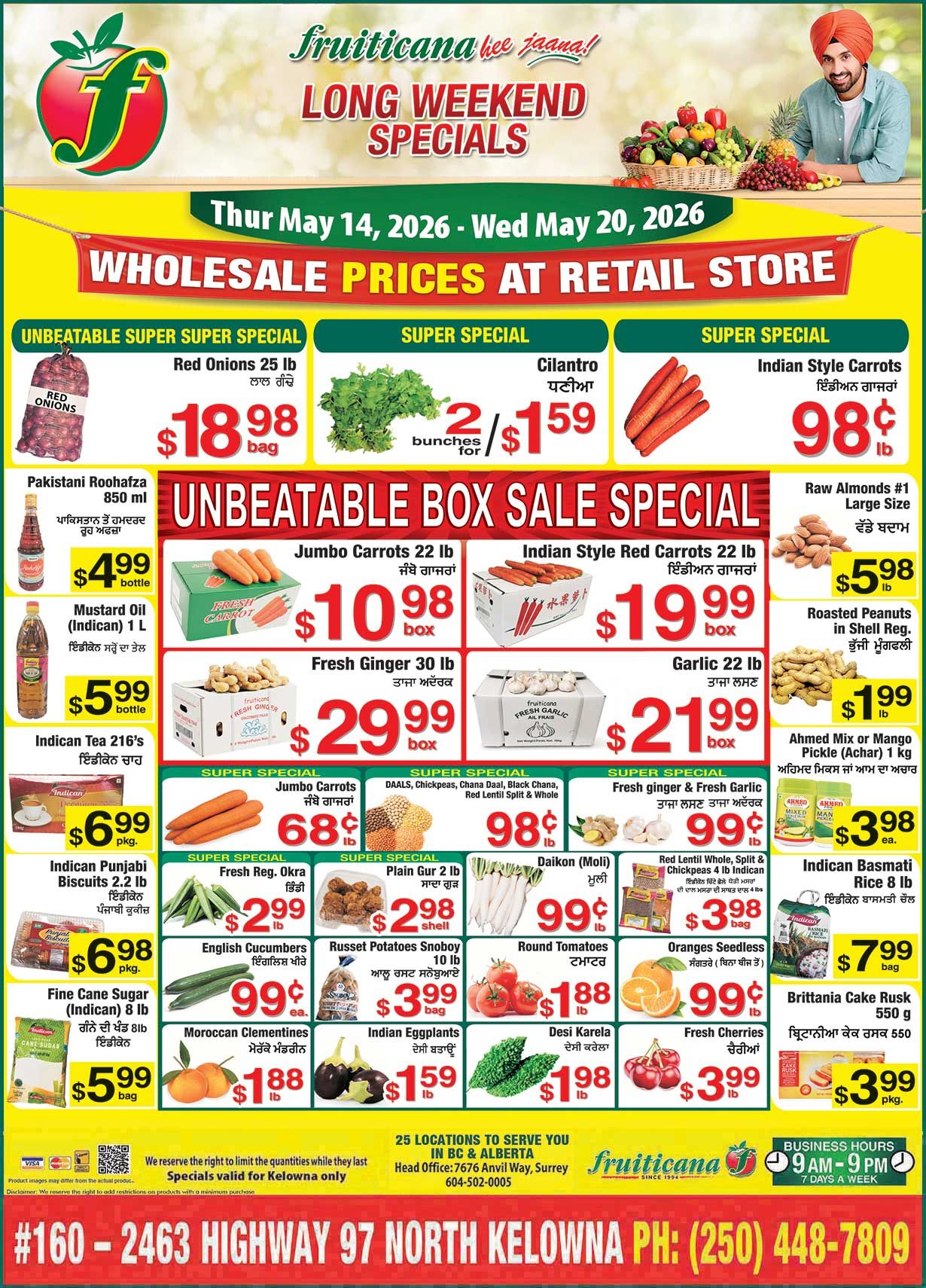 Fruiticana flyer featuring Long Weekend Specials valid from Thursday, May 14, 2026 to Wednesday, May 20, 2026, with wholesale prices at the retail store. Unbeatable Super Super Special on Red Onions, 25 lb bag for $18.98. Super Special on Cilantro, 2 bunches for $1.59, and Indian Style Carrots, large size, for 98¢ per lb. The Unbeatable Box Sale Special includes Jumbo Carrots, 22 lb box for $10.98; Indian Style Red Carrots, 22 lb box for $19.99; Fresh Ginger, 30 lb box for $29.99; and Garlic, 22 lb box for $21.99. Other items include Pakistani Roohafza, 850 ml bottle for $4.99; Indican Mustard Oil, 1 L bottle for $5.99; Indican Tea 216's for $6.99 per package; and Indican Punjabi Biscuits, 2.2 lb package for $6.98. Fine Cane Sugar (Indican), 8 lb bag for $5.99. On the right side, Raw Almonds #1, large size, are $5.98 per lb; Roasted Peanuts in Shell are $1.99 per lb; Ahmed Mix or Mango Pickle (Achar), 1 kg, is $3.98 each; Indican Basmati Rice, 8 lb bag, is $7.99; and Brittania Cake Rusk, 550 g package, is $3.99. Additional super specials include Jumbo Carrots for 68¢ per lb; DAALS, Chickpeas, Chana Daal, Black Chana, Red Lentil Split & Whole for 98¢ per lb; Fresh Ginger & Fresh Garlic for 99¢ per lb. Fresh Regular Okra is $2.99 per lb; Plain Gur, 2 lb shell, is $2.98 per shell; Daikon (Mooli) is 99¢ per lb; Red Lentil Whole, Split & Chickpeas, 4 lb Indican bag, is $3.98. English Cucumbers are 99¢ each; Russet Potatoes Snoboy, 10 lb bag, are $3.99; Round Tomatoes are $1.88 per lb; Seedless Oranges are 99¢ per lb; Moroccan Clementines are $1.88 per lb; Indian Eggplants are $1.59 per lb; Desi Karela is $1.98 per lb; and Fresh Cherries are $3.99 per lb. Specials are valid for Kelowna only. Fruiticana business hours are 9 AM to 9 PM, 7 days a week. The store is located at #160 - 2463 Highway 97 North, Kelowna.