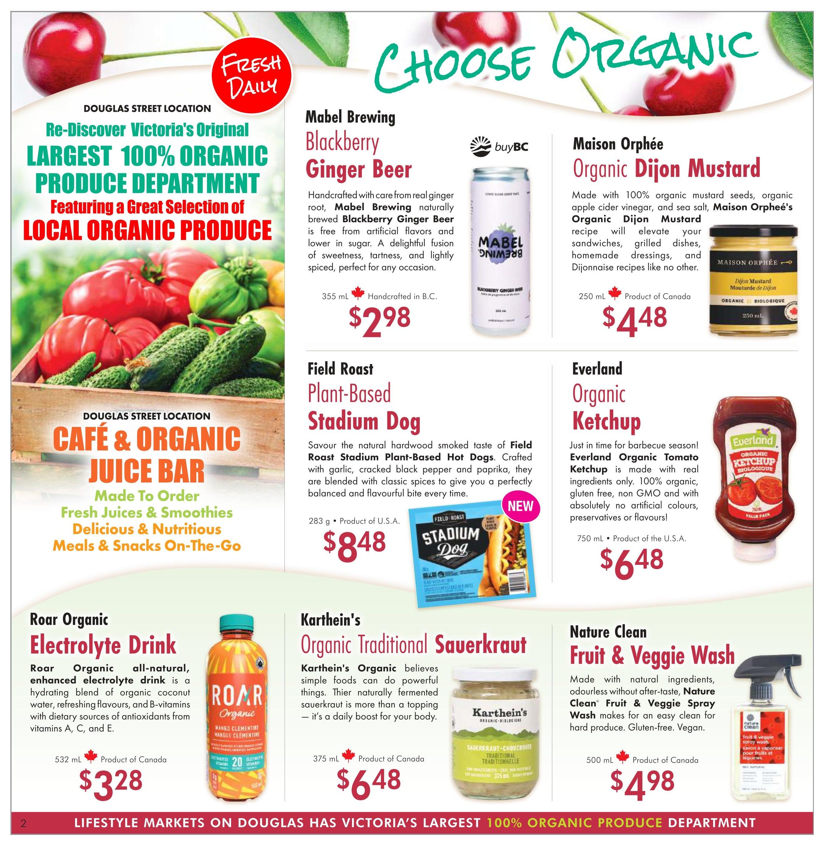 Lifestyle Markets flyer page 2 features the Douglas Street Location's 'Largest 100% Organic Produce Department' and 'Café & Organic Juice Bar' offering made-to-order fresh juices, smoothies, meals, and snacks. Featured organic products include Mabel Brewing Blackberry Ginger Beer for $2.98, Maison Orphée Organic Dijon Mustard for $4.48, Field Roast Plant-Based Stadium Dogs for $8.48, Everland Organic Tomato Ketchup for $6.48, Roar Organic Electrolyte Drink for $3.28, Karthein's Organic Traditional Sauerkraut for $6.48, and Nature Clean Fruit & Veggie Wash for $4.98.