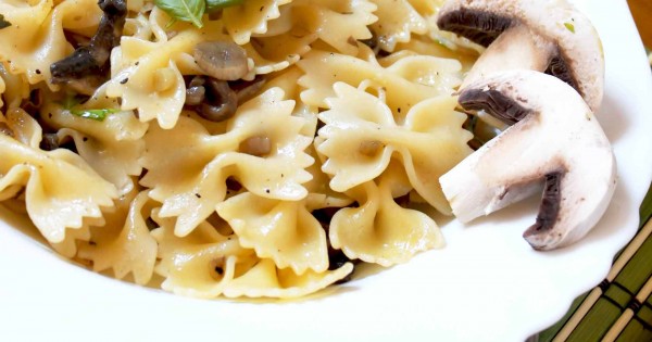 Farfalle with mushrooms, raw ham chips